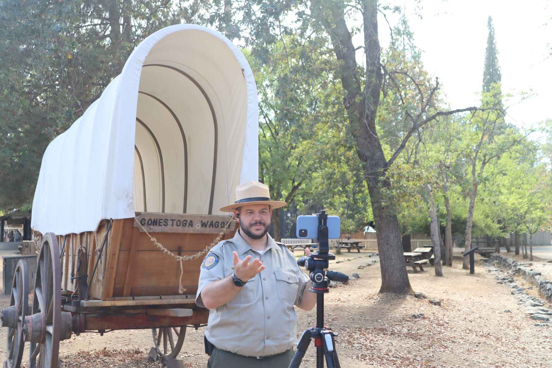 Staff talking to technology in front of wagon